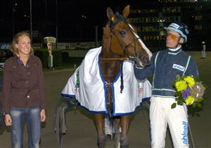 Lite hästrädd ser Kajsa Bergqvist ut att vara efter att hon delat ut pris till Stig H Johansson. Segerhästen var fina Nouveau Riche som enkelt vann V65-1. Foto: Leif Norberg/ALN.