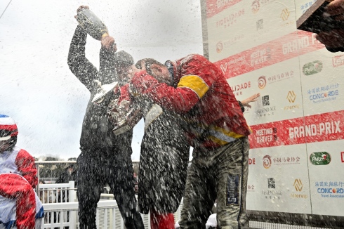 Timo Nurmos duschar Björn Goop med champagne efter segern i Prix de France. Foto: Jll-letrot. Foto av Jean Luc LAMAÈRE ©JLL-LeTROT