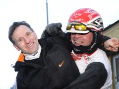 Tidigare brottaren Kent-Olle Johansson kopplar ett vänskapligt nacksving på kusken Nicolaj Andersen efter miljonskrällen med Queen Koea. Foto: Daniel Larsson/DL Media Foto av Kanal 75