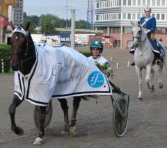 Maharajah i segerdefilering, elegant flankerad av Mats Holmstedt och hästen Nils från K1. Foto; Travkompaniet